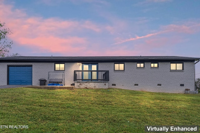 back of property with a garage, brick siding, and crawl space