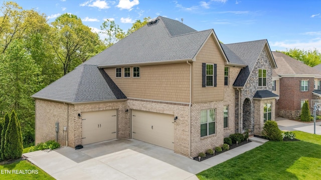 view of side of property featuring a garage, a shingled roof, driveway, and a lawn