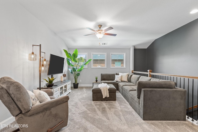 living room featuring carpet floors, a ceiling fan, visible vents, baseboards, and lofted ceiling