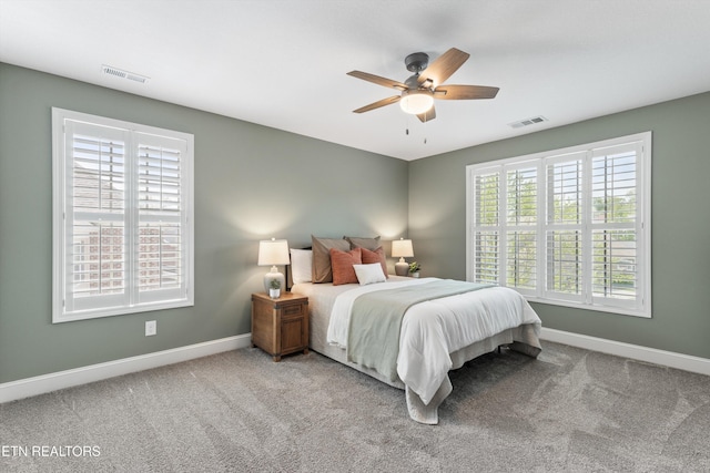bedroom with baseboards, visible vents, and carpet