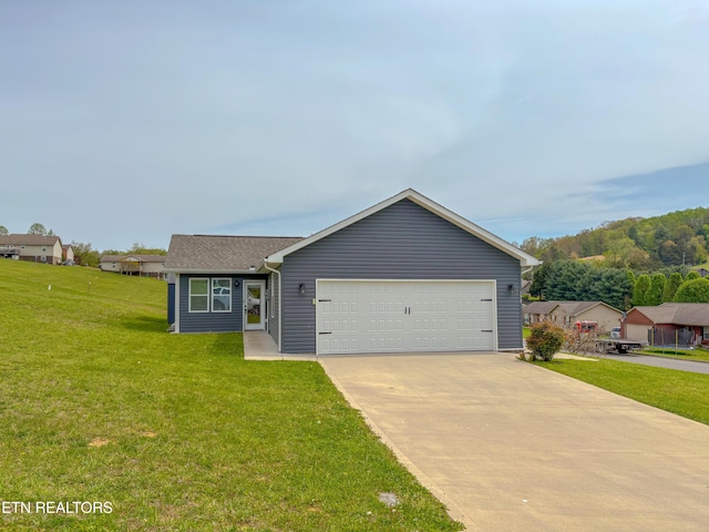 ranch-style house featuring a front lawn, driveway, and an attached garage