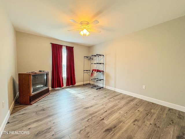 miscellaneous room featuring baseboards, wood finished floors, and a ceiling fan