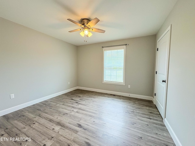 unfurnished room with baseboards, wood finished floors, and ceiling fan