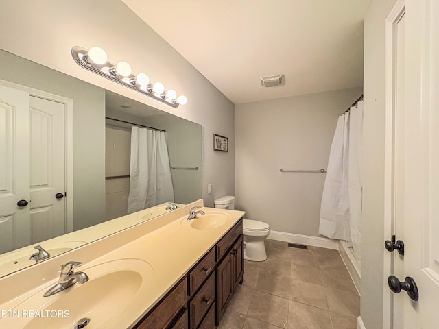 bathroom featuring toilet, a sink, and visible vents