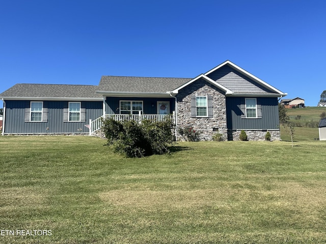 view of front of property with covered porch, board and batten siding, and a front yard