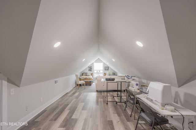office space with lofted ceiling, visible vents, baseboards, and wood finished floors