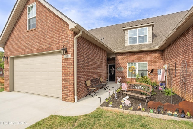 traditional-style home with concrete driveway, brick siding, a shingled roof, and a garage