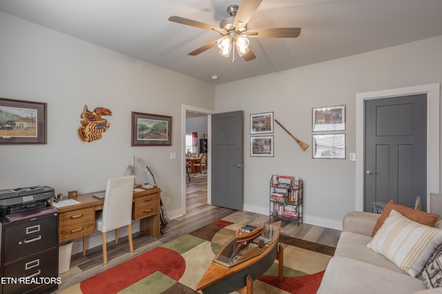 office area with ceiling fan, baseboards, and light wood-type flooring