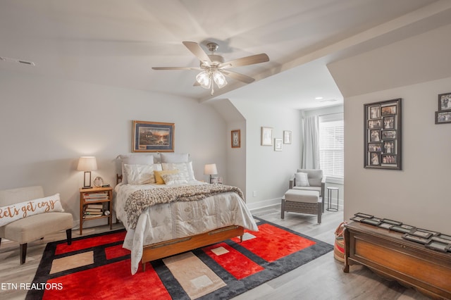 bedroom featuring visible vents, baseboards, a ceiling fan, and wood finished floors