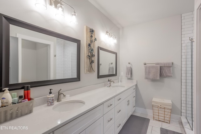 full bathroom featuring tile patterned floors, baseboards, a sink, and double vanity