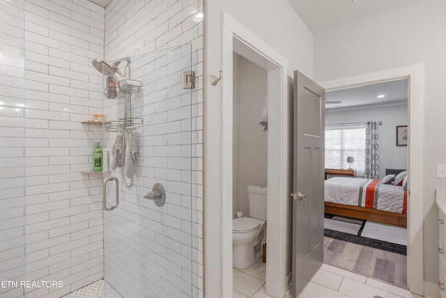 ensuite bathroom with tile patterned flooring, toilet, a stall shower, and ensuite bathroom