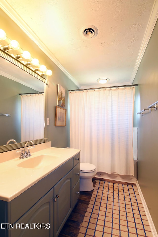 bathroom with visible vents, toilet, vanity, ornamental molding, and a textured ceiling
