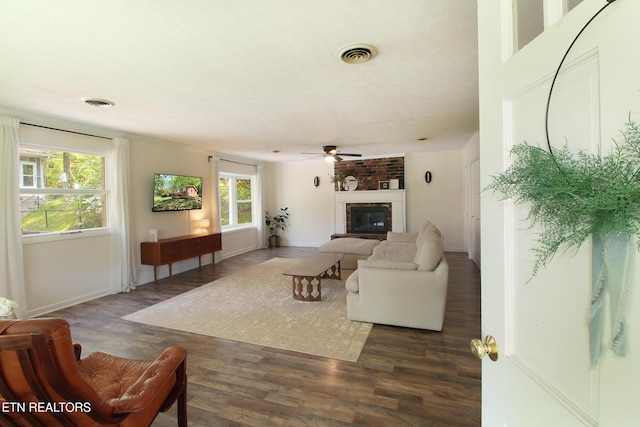living area featuring a fireplace, wood finished floors, and visible vents