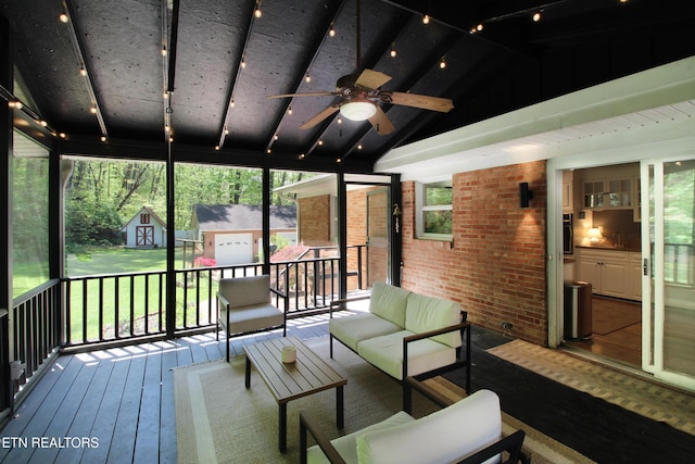 deck featuring an outbuilding, a sink, a ceiling fan, a shed, and an outdoor living space