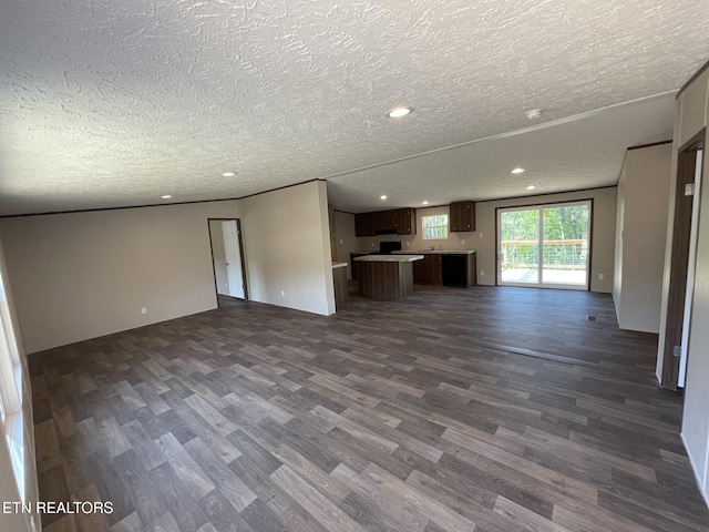 unfurnished living room with dark wood-style flooring, a textured ceiling, and recessed lighting