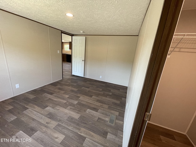 unfurnished bedroom featuring wood finished floors, a textured ceiling, a closet, visible vents, and recessed lighting
