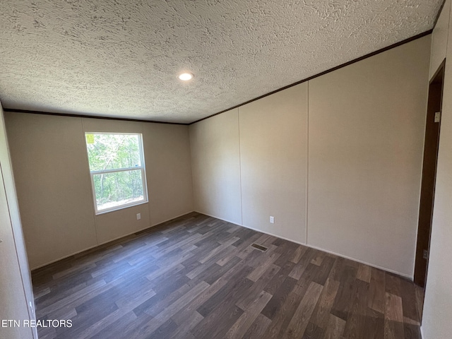 unfurnished room featuring recessed lighting, ornamental molding, dark wood-type flooring, a decorative wall, and a textured ceiling