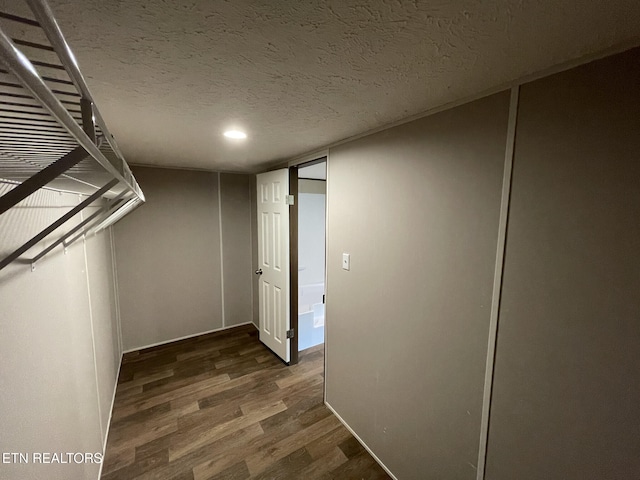 corridor with wood finished floors, a textured ceiling, and recessed lighting