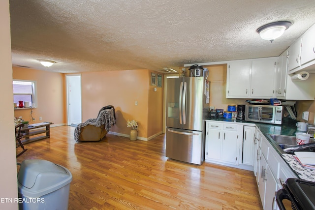 124 E Wadsworth Cir, Oak Ridge, TN 37830 - kitchen featuring stainless steel refrigerator with ice dispenser, a textured ceiling, range, and light wood-style floors