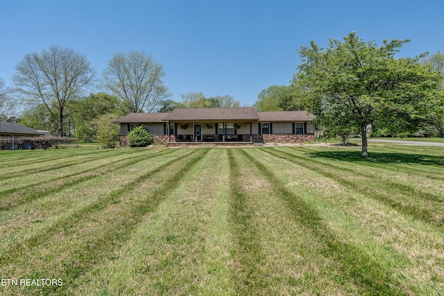 view of front facade featuring a porch, a front yard, and an attached garage