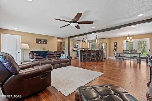 living area with recessed lighting, dark wood-type flooring, a ceiling fan, baseboards, and a textured ceiling