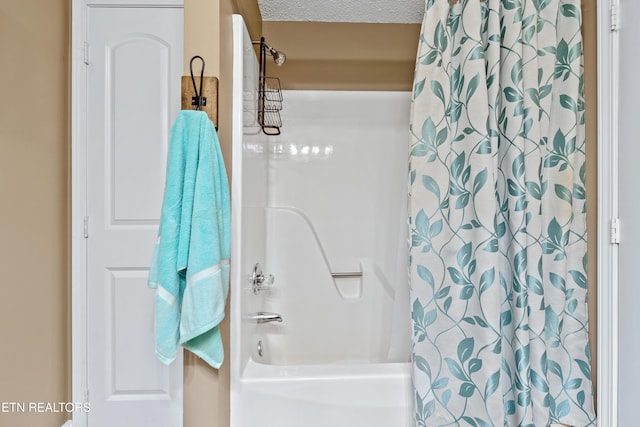 bathroom with a textured ceiling and shower / tub combo with curtain