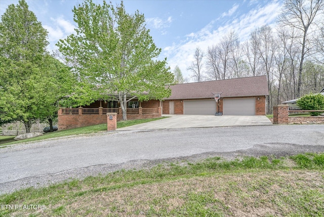 view of front of home with an attached garage, driveway, and brick siding