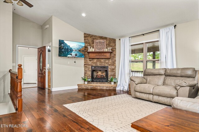living room featuring baseboards, ceiling fan, a fireplace, high vaulted ceiling, and wood-type flooring