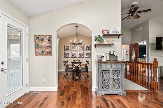 kitchen with hardwood / wood-style flooring, lofted ceiling, visible vents, and ceiling fan with notable chandelier