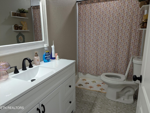 bathroom featuring toilet, tile patterned floors, vanity, and curtained shower