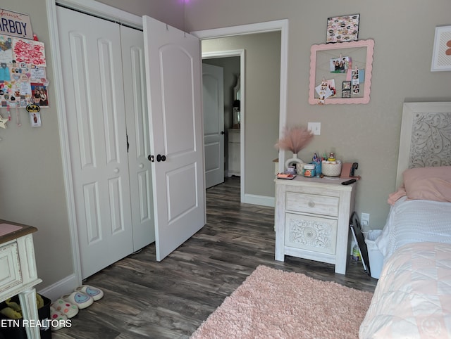 bedroom with a closet, baseboards, and dark wood-style floors