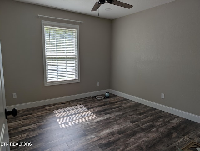 empty room featuring baseboards, dark wood-style floors, and ceiling fan
