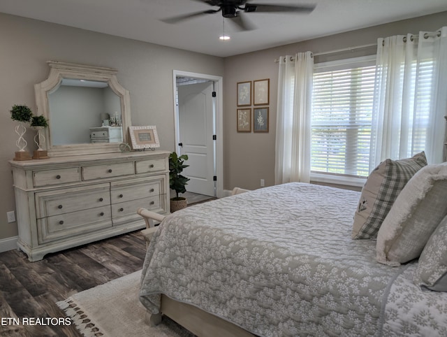 bedroom with ceiling fan, baseboards, and dark wood-style flooring