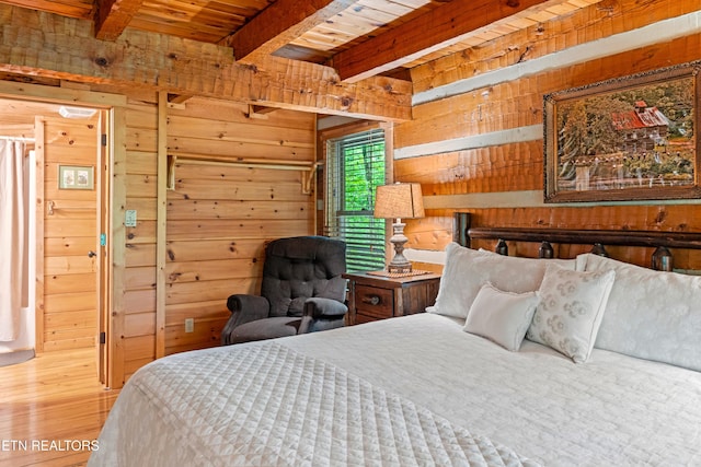 bedroom with wooden walls and beam ceiling