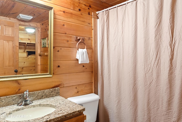 full bathroom featuring vanity, wood walls, visible vents, curtained shower, and toilet