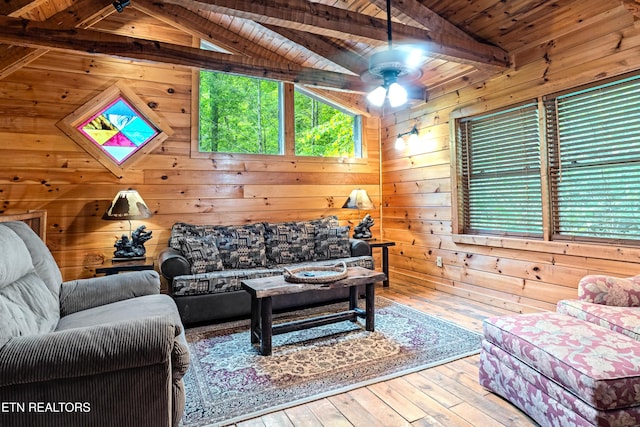 living area featuring wood walls, wood ceiling, a ceiling fan, and hardwood / wood-style floors