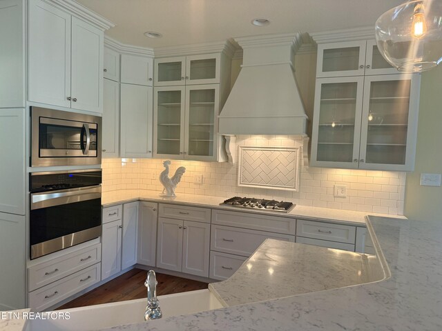 11969 Lakehurst Ln, Knoxville, TN 37934 - kitchen with stainless steel appliances, custom range hood, light stone counters, tasteful backsplash, and recessed lighting