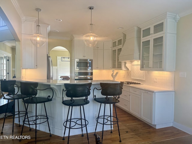 11969 Lakehurst Ln, Knoxville, TN 37934 - kitchen with arched walkways, appliances with stainless steel finishes, white cabinets, a peninsula, and ornamental molding