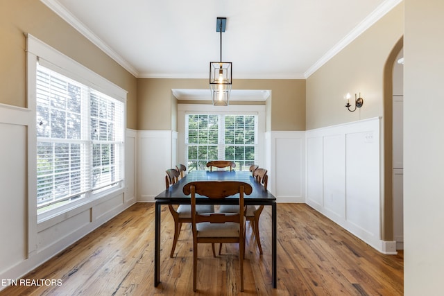 11969 Lakehurst Ln, Knoxville, TN 37934 - dining space with a decorative wall, crown molding, arched walkways, a wainscoted wall, and light wood-style flooring