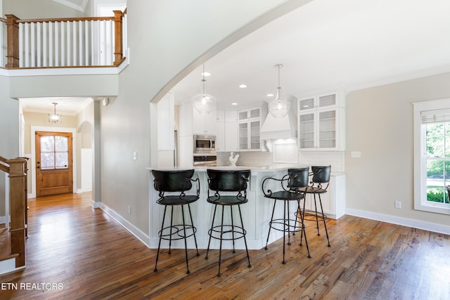 11969 Lakehurst Ln, Knoxville, TN 37934 - kitchen with stainless steel appliances, arched walkways, backsplash, wood finished floors, and crown molding
