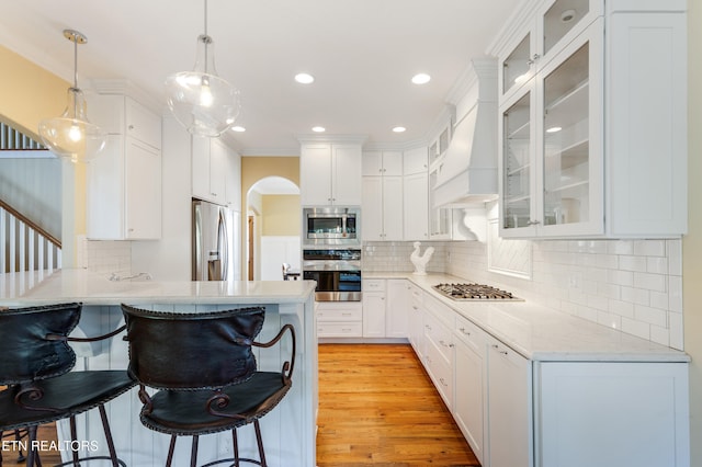 11969 Lakehurst Ln, Knoxville, TN 37934 - kitchen featuring appliances with stainless steel finishes, a kitchen bar, decorative backsplash, a peninsula, and white cabinetry