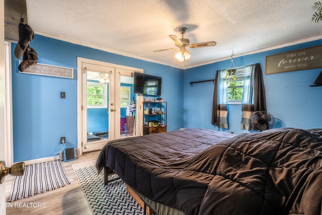 bedroom with crown molding, wood finished floors, ceiling fan, a textured ceiling, and french doors
