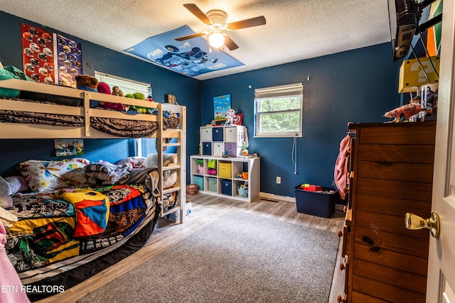 bedroom with baseboards, a textured ceiling, ceiling fan, and wood finished floors