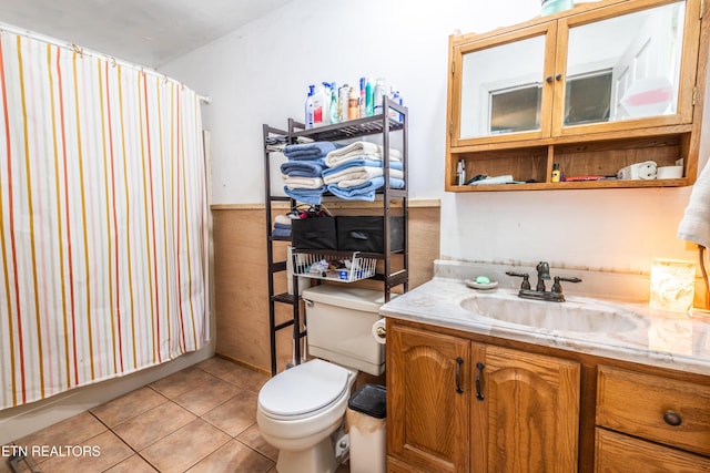 bathroom with vanity, wainscoting, toilet, a shower with shower curtain, and tile patterned floors