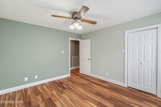 1109 Greywood Dr, Knoxville, TN 37923 - unfurnished bedroom with wood finished floors, baseboards, a textured ceiling, a ceiling fan, and a closet