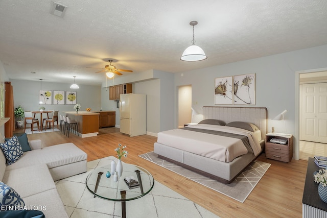 1109 Greywood Dr, Knoxville, TN 37923 - bedroom featuring freestanding refrigerator, light wood-style floors, and a textured ceiling