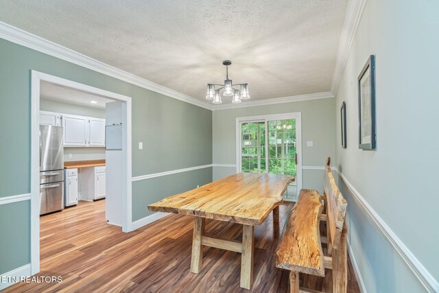1109 Greywood Dr, Knoxville, TN 37923 - dining space with light wood finished floors, a chandelier, crown molding, baseboards, and a textured ceiling