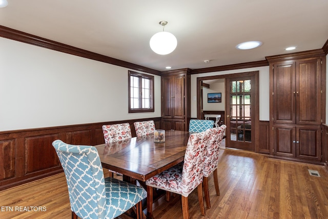 dining space featuring crown molding, a wealth of natural light, and light wood-type flooring