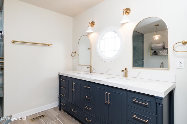 bathroom featuring double vanity, visible vents, baseboards, and a sink