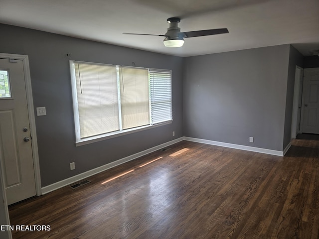 interior space with ceiling fan, a wealth of natural light, dark wood-style floors, and visible vents